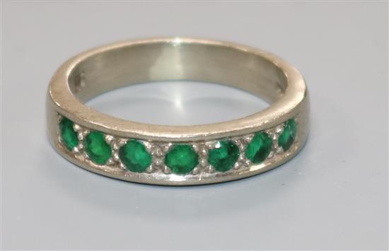 A modern 18ct white gold and seven stone emerald half eternity ring, size P.